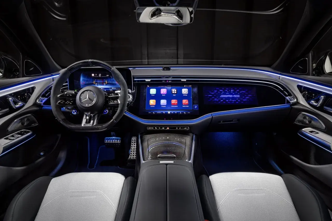 Wnętrze e53 AMG z podświetlanymi na niebiesko detalami, dużymi ekranami i sportową kierownicą.