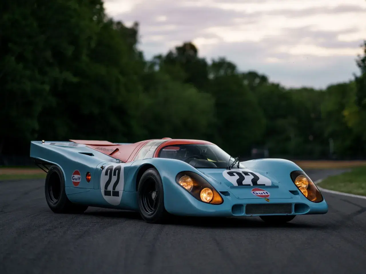Legenda wyścigowa Porsche 917 w barwach Gulf, z numerem 22, gotowa do startu na torze.