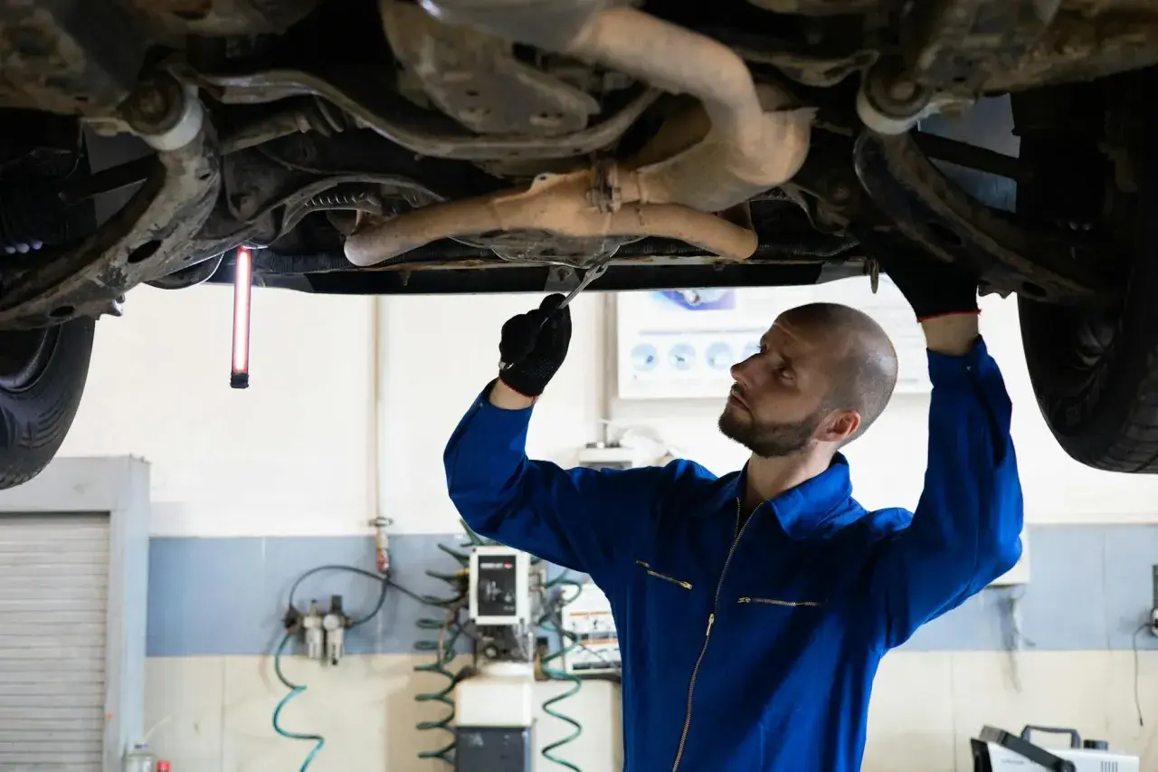 Mechanik sprawdza podwozie Audi, szukając przyczyny błędu DTC P0420.