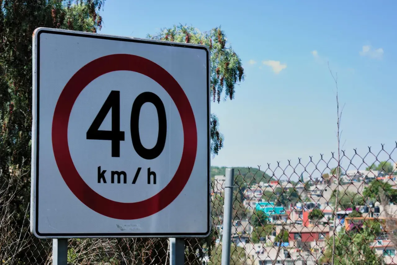 Znak ograniczenia prędkości 40 km/h. Uważaj na drogach, zwłaszcza w pobliżu zabudowań.
