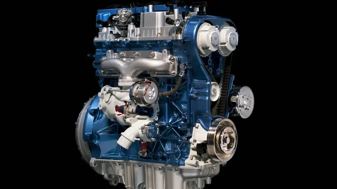 Błękitny silnik 1.6 Ecoboost z turbosprężarką i paskiem rozrządu, prezentowany na czarnym tle.