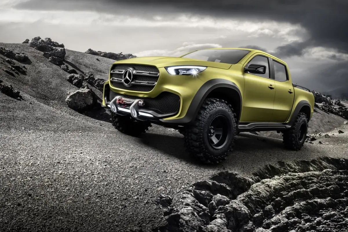 Żółty Mercedes pickup z wyciągarką gotowy na terenową przygodę po kamienistym pustkowiu.