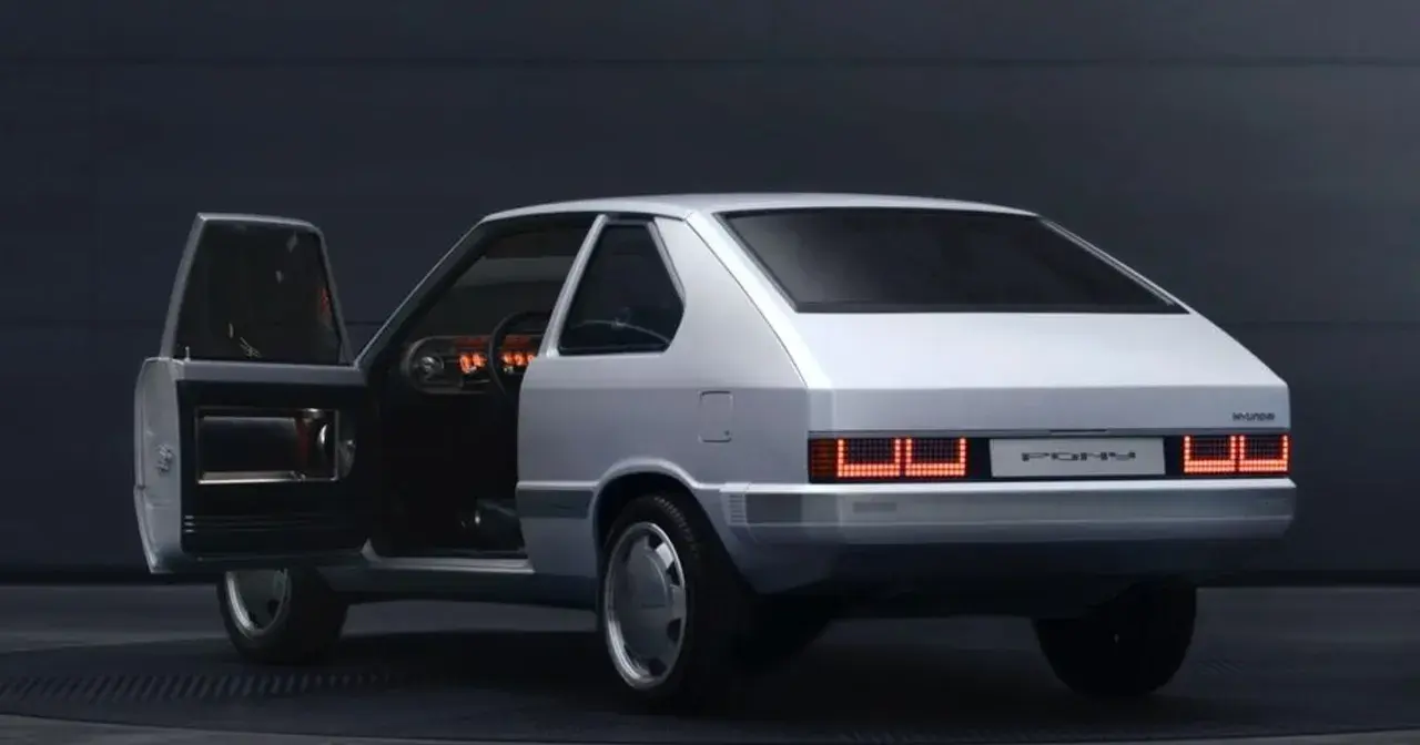 Biały Hyundai Pony z lat 80. z otwartymi drzwiami, widoczne wnętrze i charakterystyczne tylne światła.