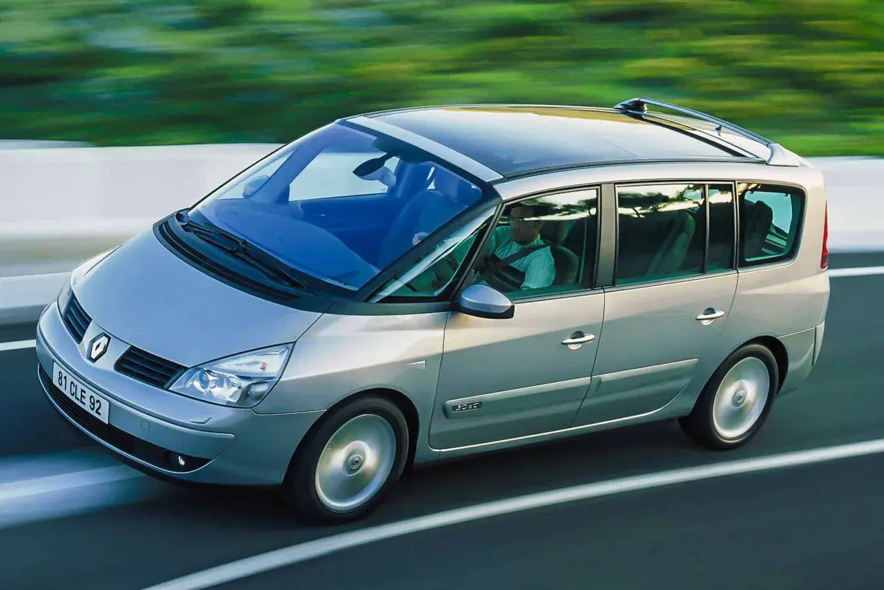 Srebrny Renault Espace 2024 z panoramicznym dachem sunie po drodze, zapewniając komfortową podróż.