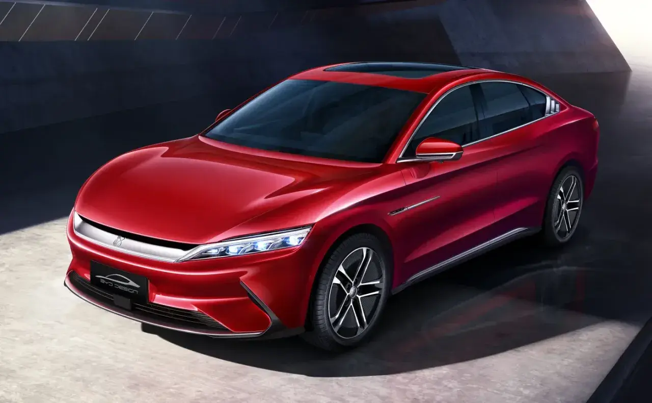 Błyszczący, czerwony sedan BYD Han prezentuje nowoczesny design z eleganckimi liniami i futurystycznymi światłami.