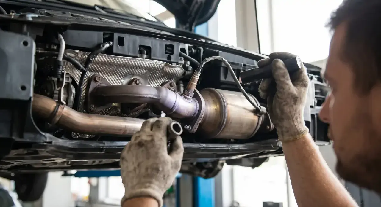 Mechanik sprawdza układ wydechowy Toyoty, szukając przyczyny błędu DTC P0420.