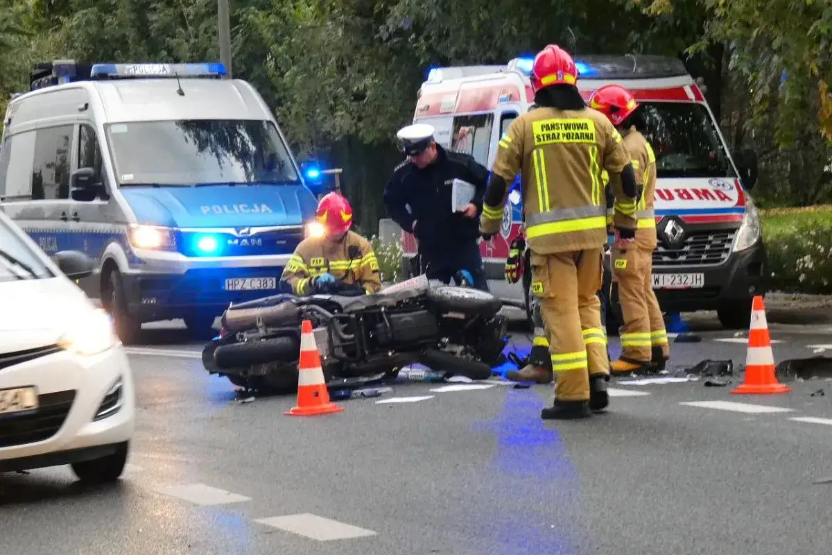 Po wypadku motocyklowym na drodze pracują strażacy i policja. Na miejscu jest też karetka. Borkoś, kierowca motocykla, jest badany.