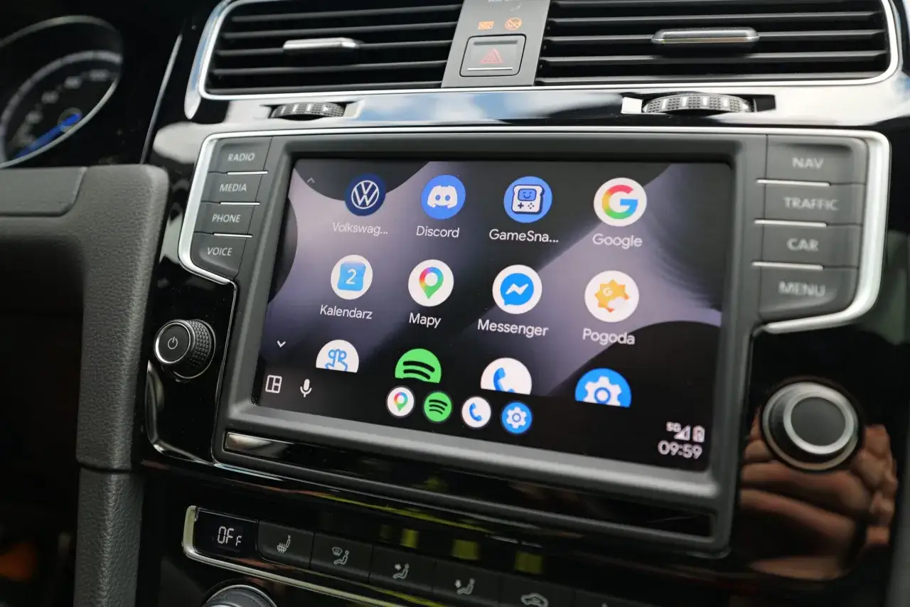 Ekran samochodu z widoczną aplikacją Android Auto. Ikony Volkswagen, Discord, Mapy Google, Kalendarz, Messenger i Pogoda.