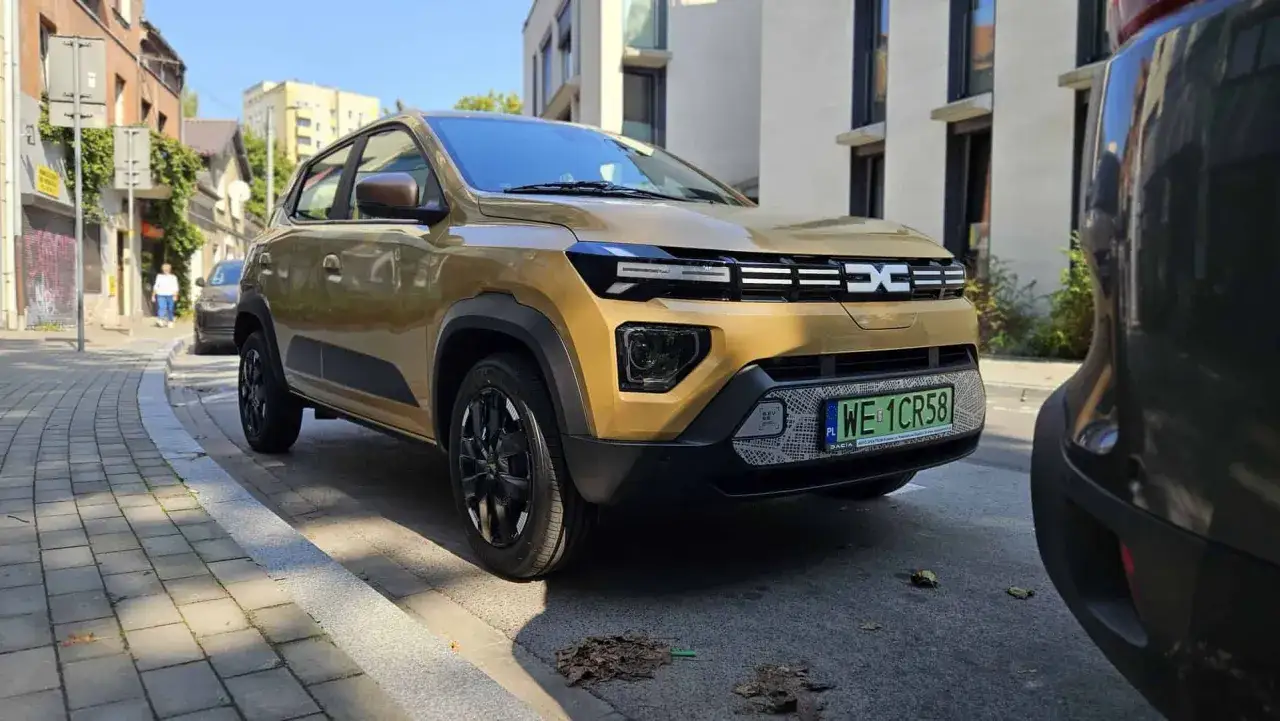 Złoty Dacia Spring na ulicy, idealny do miasta. Sprawdź, jaka jest dacia spring cena i zacznij oszczędzać!