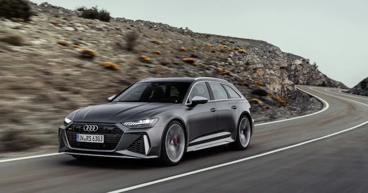 Szary Audi RS6 Avant pędzi po krętej górskiej drodze, budząc podziw.